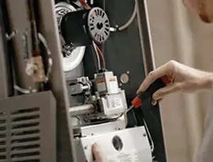 Furnace repair technician inspecting internal components and wiring in San Francisco, CA