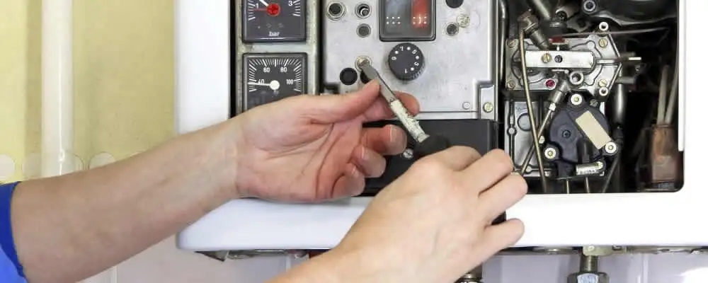 Heating repair technician adjusting boiler controls and components in San Francisco, CA