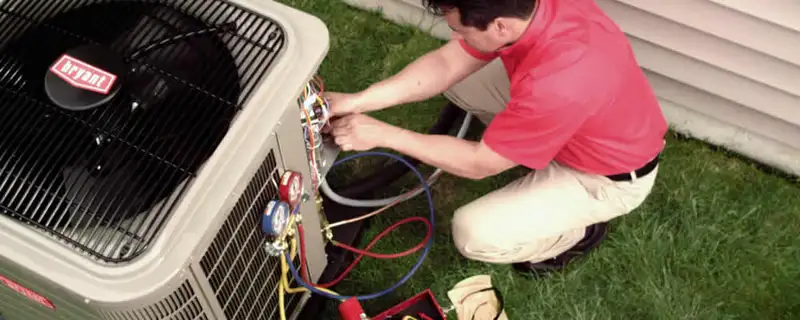 HVAC technician servicing an outdoor air conditioner unit in San Francisco, CA
