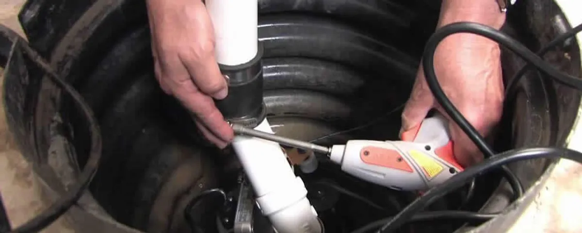 Sump pump installation technician connecting PVC discharge piping in San Francisco, CA