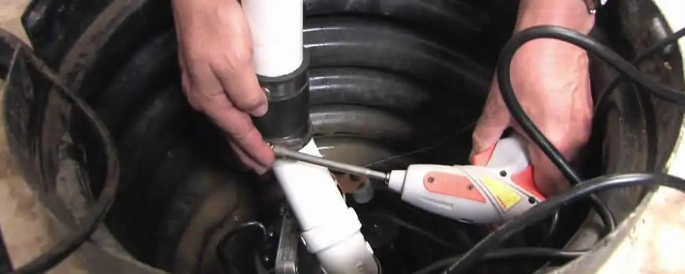 Sump pump installation technician connecting PVC discharge piping in San Francisco, CA