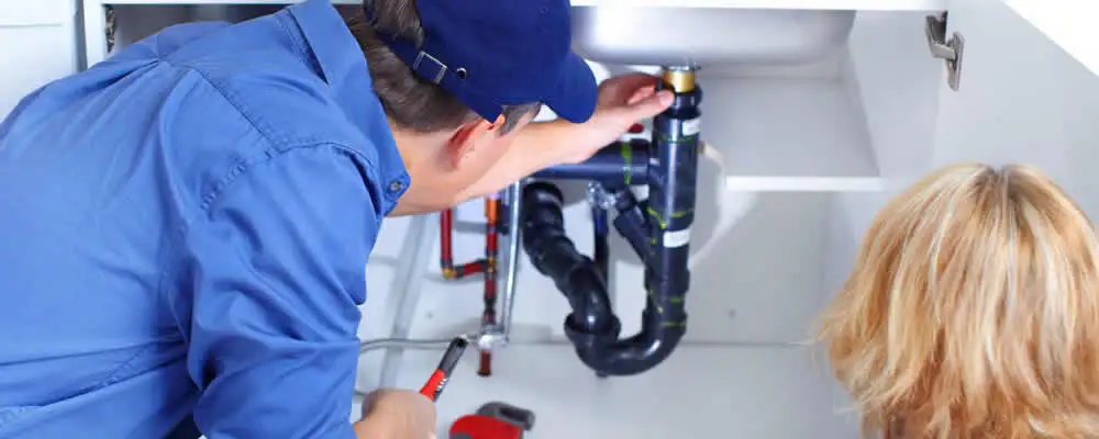 Plumber repairing under-sink drain pipes and fittings in San Francisco, CA